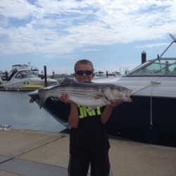 little boy holding his freshly caught fish